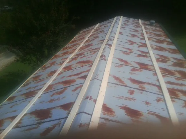 Rusted metal roof panels with new wood purlins before replacement — Storm Damage Roof Repair in Enola by Roofing Brothers
