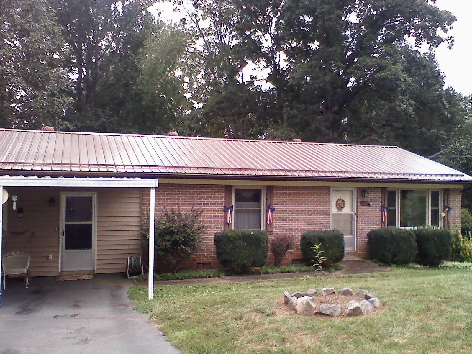 Bronze metal roof and carport on a brick ranch home — Roof Repair work by our crew in Enola
